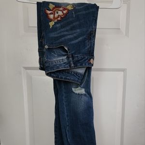distressed jeans with a rose embroidered on it size 7/8